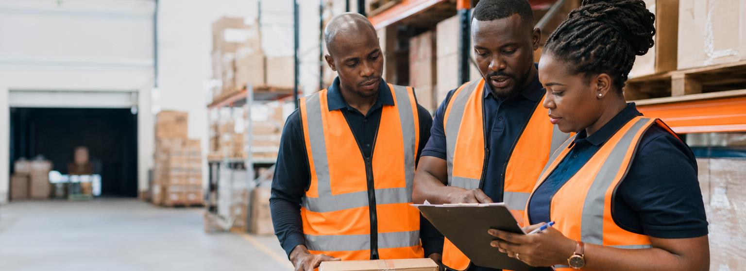 A supply team reviewing goods and documentation in a warehouse